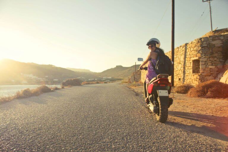 woman riding scooter at sunrise
