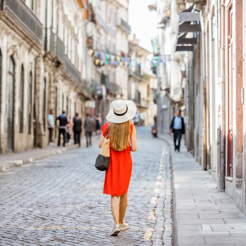 build the confidence to travel solo
Women in red dress and sunhat waling away from the camera along cobbled street