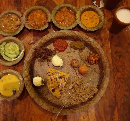 Indian meal with triangle of flat bread, various herbs and spices and 3 small bowls with different types of curry