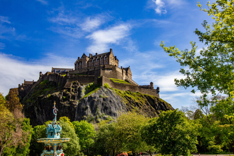Edinburgh Castle against a backdrop of blue sky, taken from Princess Street Gardens