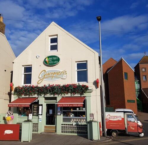 Day Trips from Edinburgh In search of ice cream
Shop front of Giacopazzis with green paintwork sign in gold cursive writing, windows on either side of door and red and white ice cream van in background