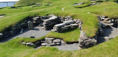 Shetland Highlights history
Ancient ruins excavated, outline of stone buildings surrounded by mown green grass 