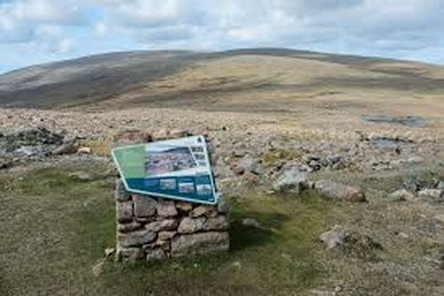 Rocky hill top with sign on stone pillar