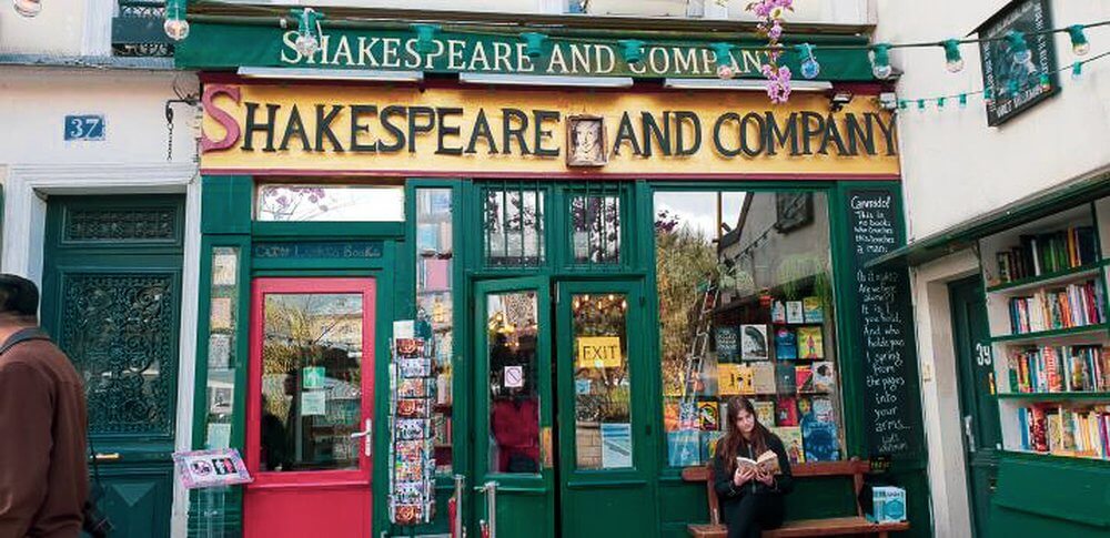 Musings from Paris Shop front of Shakespeare and Company bookshop, green paint , pink door