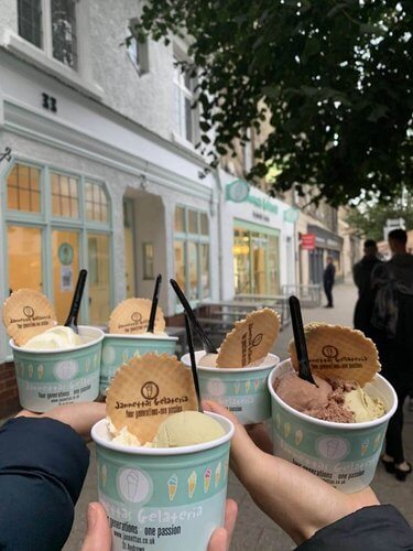 Day Trips from Edinburgh In search of ice cream
3 hands holding tubs of ice cream with black spoons and wafers, ice cream shop ion background