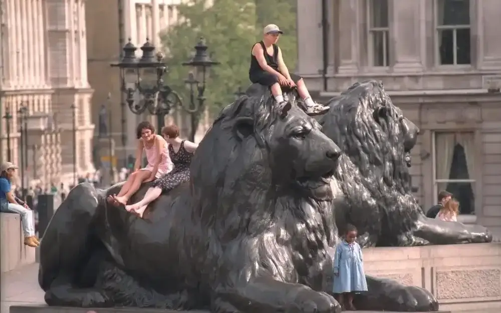 Things that will make you fall in love with London
Giant marble l ions of Trafalgar Square, with a boy dressed in black vest and shorts with a white baseball cap, sat on it's head and 2 women sat on it's back and a child in a light blue coat standing between its paws 