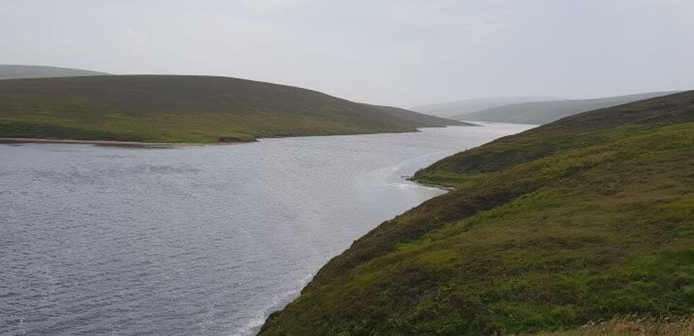 Road Trip Shetland
Looking down on loch, grey water, grey misty sky from green hills to 2 sides of water