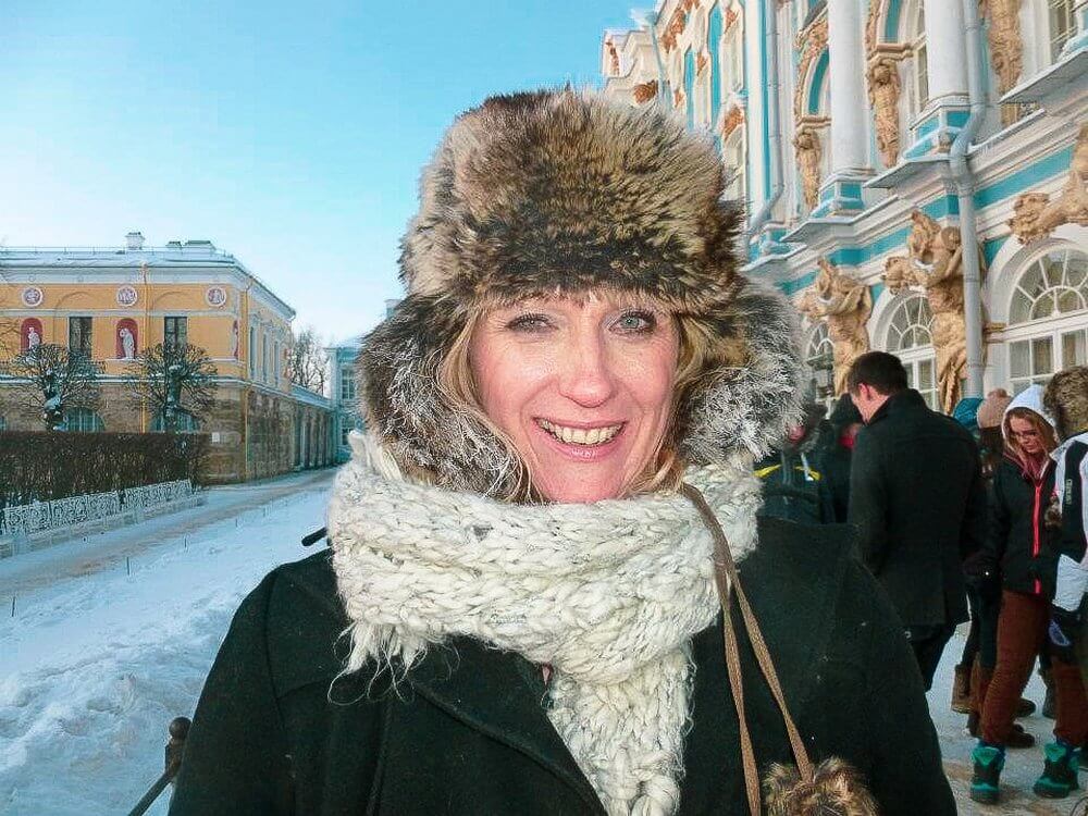 Woman with fur hat and scarf standing outside the Summer Palace, in the snow