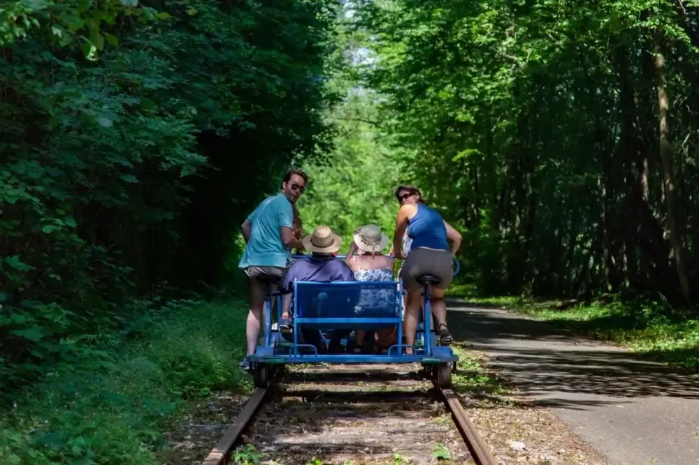 Travel trends, multi-generational family holidays.  Family with grandparents enjoying day out on bike on tracks