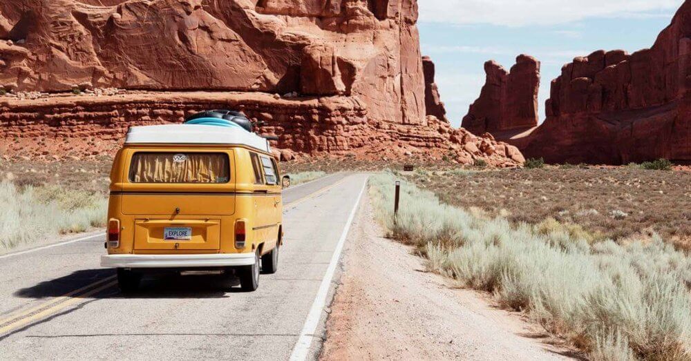 Travel Trends, roadtrips.  Yellow VW campervan on roadtrip through rocky pass