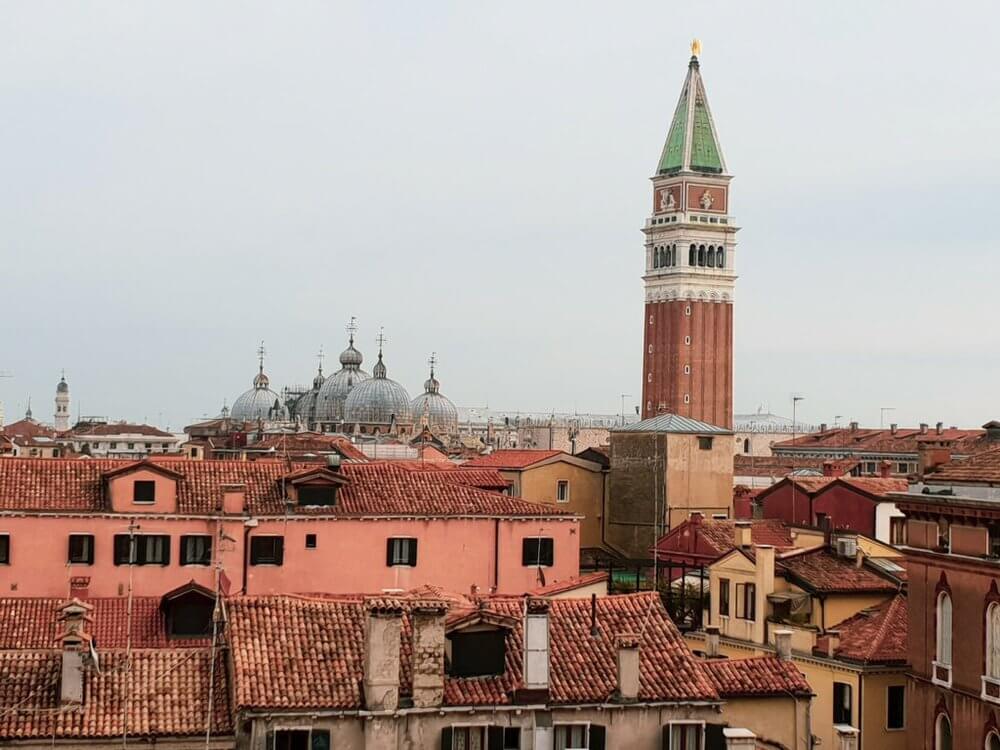 Being a tourist in Venice
Red rooftops of Venice with St Mark's tower and domes of Basillica in distance, grey sky