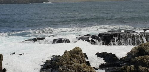 Sea rushing in white waves over rocks shetland trip