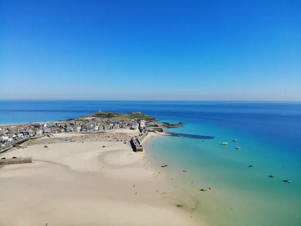 Travel trends, domestic travel.  Drone shot of St Ives beach, Cornwall, England with low tide and town in background