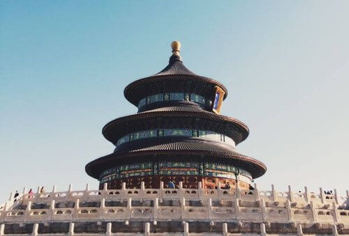 China
Temple of heaven against light blue sky circular building with 3 tiers each with a brown tiled sloping roof and blue and white tiles between.  White stone decorative wall to foreground