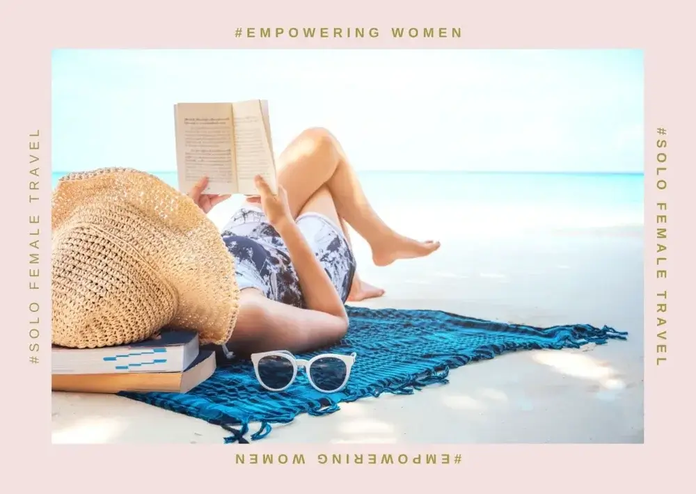 Woman lying on a blue towel on a sandy beach, wearing a straw sunhat and reading a book