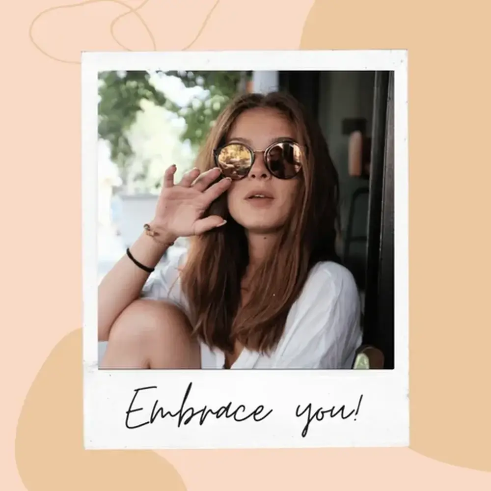 Young woman with brown hair and sunglasses sitting with text 'embrace you'