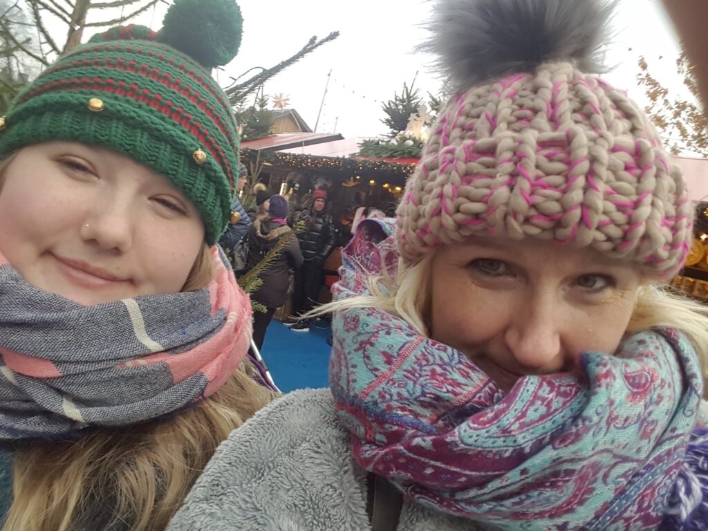 Image of 2 women in wooly hats enjoying the Edinburgh Christmas market