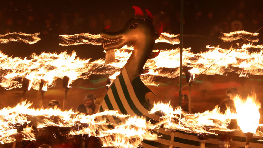 Viking galley surrounded by flaming torches