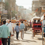 India Delhi Market, busy street with many people walking and rickshaws
