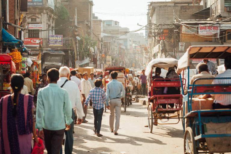 India Delhi Market, busy street with many people walking and rickshaws